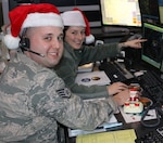 Staff Sgt. Tom Silva and Staff Sgt. Rachael Alcorta practice Santa tracking at the Eastern Air Defense Sector in Rome. EADS plays a supporting role in NORAD's annual Santa tracking. 