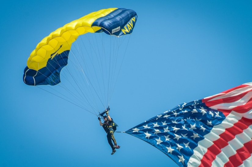 A man parachutes with a flag attached to him.