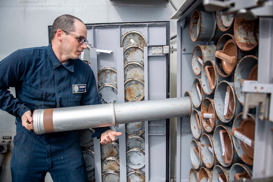 Technician stows a chaff round into a ready service locker aboard the Arleigh Burke-class guided-missile destroyer USS Milius (DDG 69)