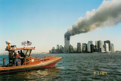 A Coast Guard RHIB off Manhattan on the morning of 11 September 2001 (not a USCG photograph).Photo by Chan Irwin, the owner of Irwin Marine in Red Bank, New Jersey.  He had taken a fast boat out into the harbor on 9/11/2001 but got turned back before the radio call request for aid was sent out.  He gave a copy of his photograph to his friend Mike Harmon who forwarded this digital copy to the Historian's Office.  

(Info. provided by Matthew Riva, WSJ Night Photo Editor, 2021).
