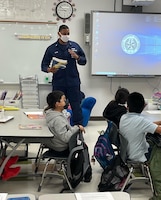 Lt. j.g. Joshua Moore, Marine Safety Security Team (MSST) Houston Partnership in Education (PIE) Coordinator, reads to students at James DeAnda Elementary School in Houston, Texas
