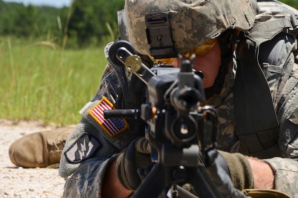 Louisiana National Guard's Sgt. William Avery, of Farmerville, Louisiana, with B Company, 3rd Battalion, 156th Infantry Regiment demonstrates different fighting positions that can be used when firing a M249 Light Machine Gun.
