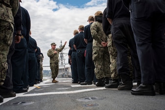 Chief of Naval Personnel Vice Adm. Rick Cheeseman  speaks to Sailors on the flight deck of USS Chosin