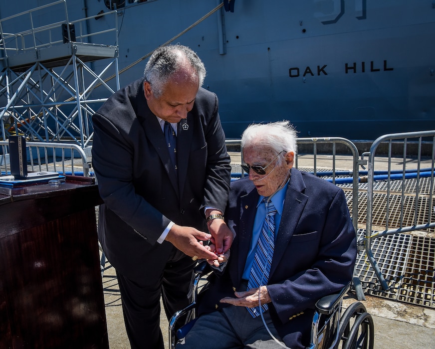 SECNAV Carlos Del Toro presents the Bronze Star Medal with Combat "V" 100-year-old World War II veteran Daniel Holihan.