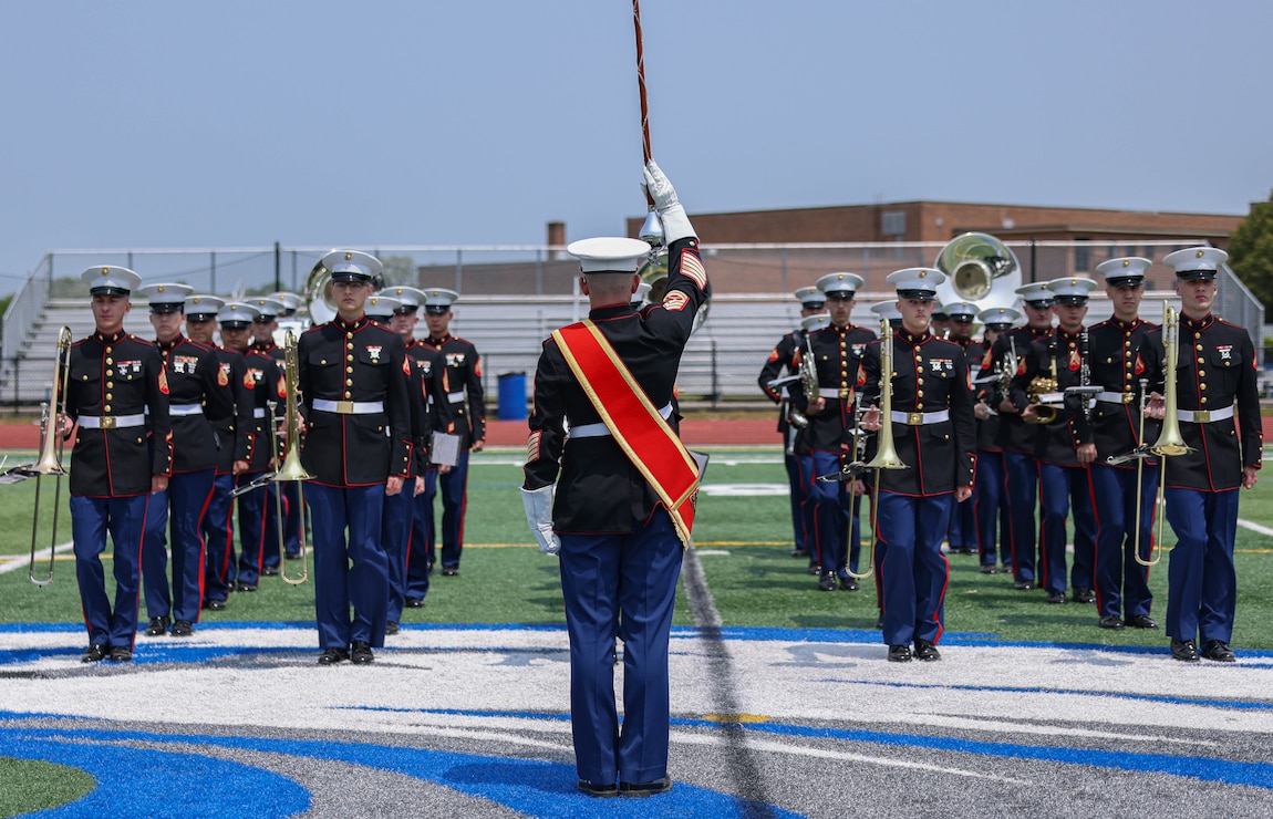 U.S. Marine Corps Gunnery Sgt. James D. Dempsey, the drum major for The Quantico Marine Band, leads the band off the field after their performance at Hauppauge High School, Long Island, New York during the first day of Fleet Week New York (FWNY), May 24, 2023. More than 3,000 service members from the Marine Corps, Navy and Coast Guard and our NATO allies from Great Britain, Italy and Canada are engaging in special events throughout New York City and the surrounding Tri-State Region during FWNY 2023, showcasing the latest capabilities of today’s maritime services and connecting with citizens. The events include free public ship tours, military static displays, and live band performances and parades. (U.S. Marine Corps photo by Lance Cpl. David Brandes)