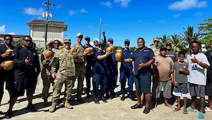 U.S. Coast Guard and U.S. Navy members stand for a photo with community members in the Republic of Palau following a boating safety class on Dec. 28, 2023