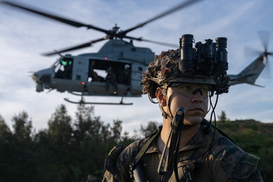A U.S. Marine with the maritime raid force, 31st Marine Expeditionary Unit, posts security for a UH-1Y Venom during a helicopter rope suspension techniques exercise at Camp Schwab, Okinawa, Japan, June 25, 2024. The training was conducted to rehearse insertion of a reconnaissance and surveillance team into a limited opening insertion point. The 31st MEU, the Marine Corps’ only continuously forward-deployed MEU, provides a flexible and lethal force ready to perform a wide range of military operations as the premiere crisis response force in the Indo-Pacific region.
