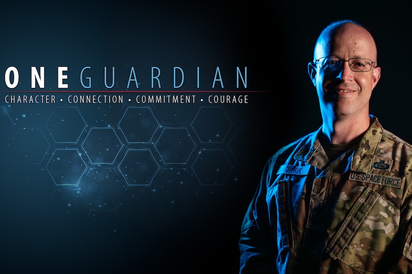 A service member poses for a photo in a graphic illustration with the words "One Guardian; character; connection; commitment; courage" to the left.