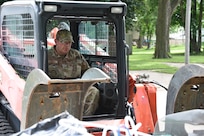 U.S. Air National Guard Tech. Sgt. Aaron Jacobson, a 185th Air Refueling Wing Civil Engineering Squadron pavements and construction equipment specialist, picks up debris using a skid steer loader in Sioux Rapids, Iowa, June 29, 2024. Airmen of the 185th ARW and 132nd Wing helped clean up debris in the wake of historic flooding in Northwest Iowa.