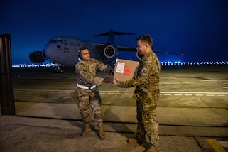 U.S. Air Force Staff Sgt. Thiago Goes, 70th Aerial Port Squadron special handler/joint inspector, gives Col. Brian Gavitt, Combined Joint Task Force - Resolute Sentinel Surgeon General and 346th Expeditionary Operational Medical Readiness Squadron commander, a box of donated blood during exercise Resolute Sentinel 2024 in Lima, Peru, May 30, 2024. The blood was requested and within 24 hours was shipped from Joint Base Charleston, South Carolina, to Lima. RS24 is a three-week exercise that will integrate combat interoperability and disaster response training, in addition to space domain awareness, medical and legal exchanges, humanitarian aid and construction projects. (U.S. Air Force photo by Senior Airman Courtney Sebastianelli)