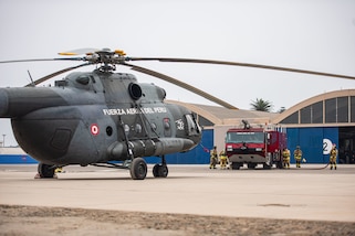 Peruvian and U.S. Air Force firefighters stage a simulated MIL Mi - 17 helicopter fire for a fire rescue evacuation training during Resolute Sentinel 2024 in Lima, Peru, June 3, 2024. Exercise RS24 is an opportunity for cultural and tactical integration between the U.S. and its allied partnered nations. (U.S. Air force photo by Airman 1st Class Sir Wyrick)