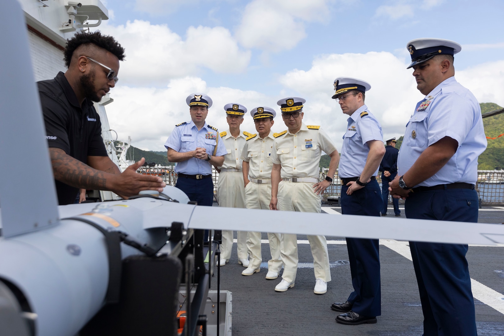 Christopher Lee, an operator of the ScanEagle small unmanned aerial system (UAS), working aboard the U.S. Coast Guard Cutter Waesche (WMSL-751), explains the role of UAS to leaders in the Japan Coast Guard during a tour of the Waesche in Maizuru, Japan, June 5, 2024. Members of the Japan and Republic of Korea Coast Guards toured the Waesche to see the capabilities the U.S. Coast Guard has to handle its mission sets. U.S. Coast Guard missions in the Indo-Pacific focus on issues directly supporting and advancing our regional partners’ efforts to protect fish stocks, ensure safety of life at sea, support environmental response, and provide disaster relief. (U.S. Marine Corps photo by Cpl. Elijah Murphy)