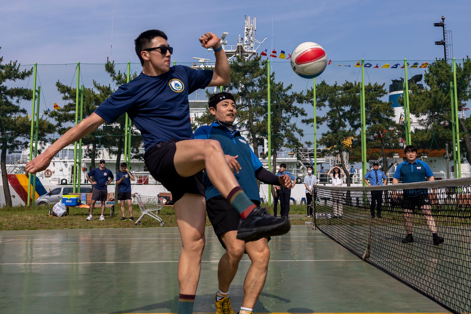 U.S. Coast Guardsmen Seaman Larry Zhou, assigned to the U.S. Coast Guard Cutter Waesche (WMSL-751), kicks a ball during a sports day in Pohang, Republic of Korea, June 10, 2024. United States and Korea Coast Guardsmen came together to play jokgu to build stronger relationship and cooperation between the servicemembers of each nation. Waesche is the second U.S. Coast Guard National Security Cutter deployed to the Indo-Pacific in 2024. Coast Guard cutters routinely deploy to the region to engage with partner nations to ensure a free and open Indo-Pacific. (U.S. Marine Corps photo by Cpl. Elijah Murphy)