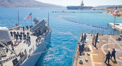 Sailors aboard USS Philippine Sea (CG 58), left, and USS Gravely (DDG 107) handle mooring lines as the Philippine Sea nests along the starboard side of Gravely in Souda Bay.