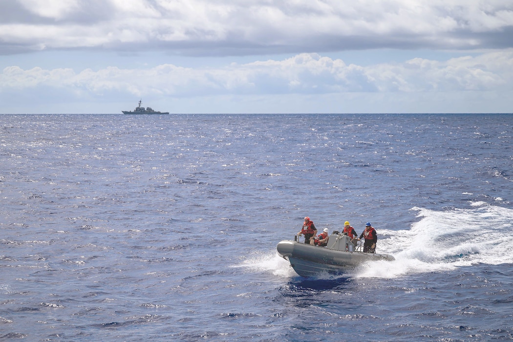 Sailors approach USS Curtis Wilbur (DDG 54) in a rigid-hull inflatable boat.