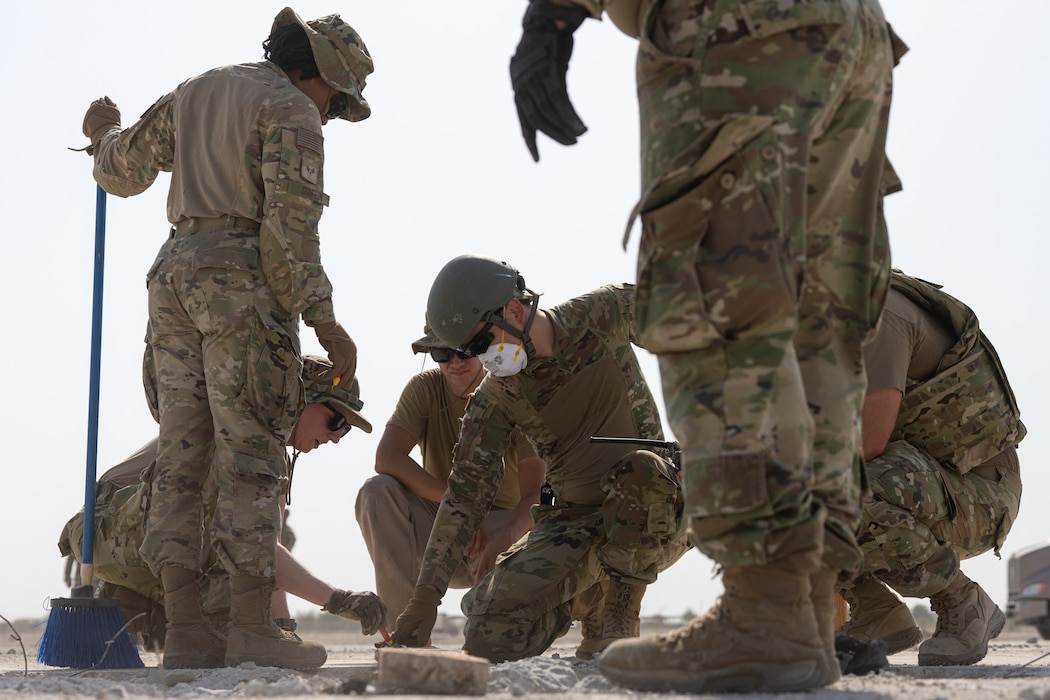 U.S. Air Force Airmen assigned to the 379th Expeditionary Civil Engineer Squadron use a measuring tool