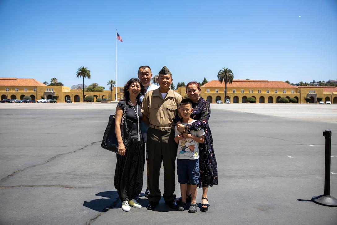 U.S. Marine Corps Pfc. Jiang Xinnian, a native of China and recruited from Pasadena, Calif. with Echo Company, 2nd Recruit Training Battalion, poses for a photo with his family after a naturalization ceremony at Marine Corps Recruit Depot, San Diego, June 27, 2024. The naturalization ceremony took place during family day to recognize Marines who became United States citizens by completing Basic Training. (U.S. Marine Corps photo by Sgt. Yvonna Guyette)