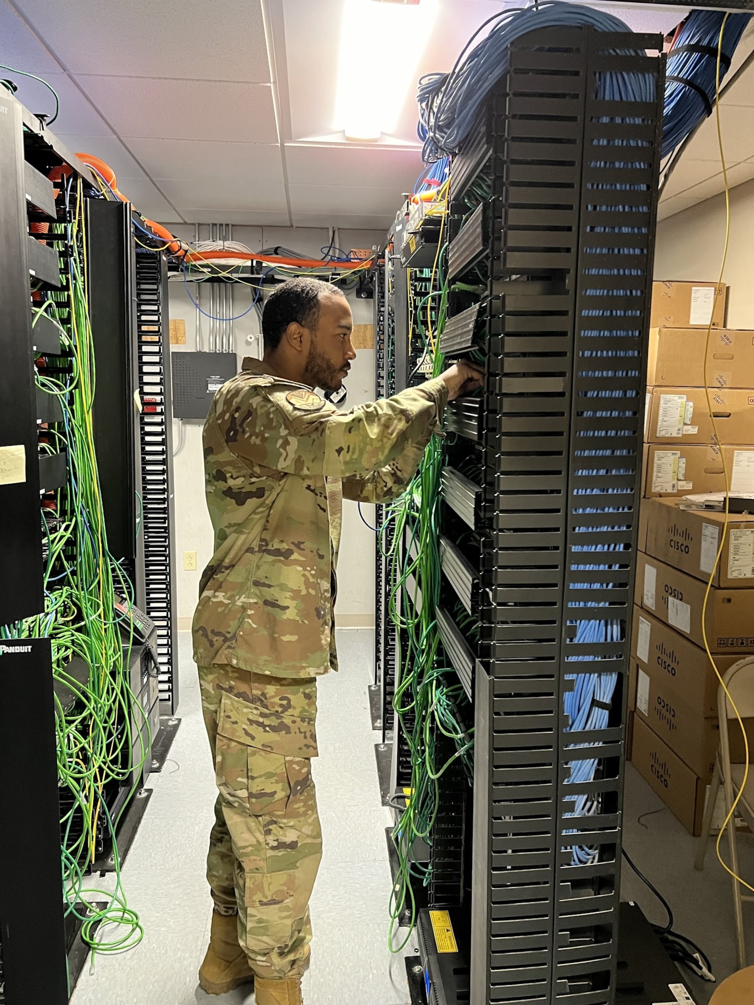 Staff Sgt. DeAnthony Norales of the 212th Engineering Installation Squadron, Otis Air National Guard Base, Mass., reroutes network cabling after upgrading the switches in the rack. Airmen peformed network infrastructure upgrades at Joint Base Langley-Eustis in May 2024.