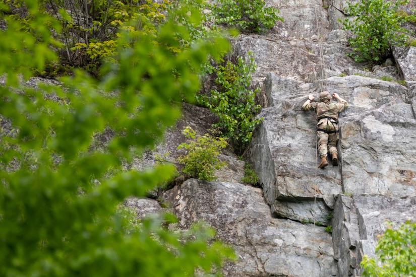 A person scales the side of a vertical rock face.